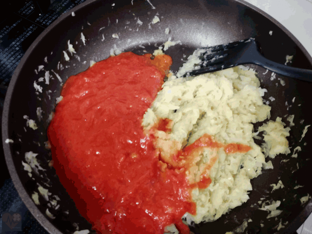 ペースト状したトマトとすりおろしたニンニクを入れる